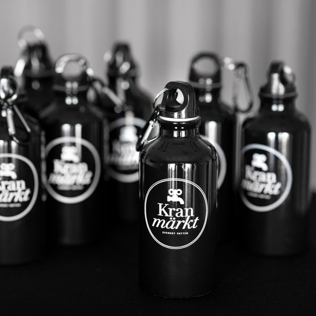 Vattenflaskor i metall med symbolen för Kranmärkt på.