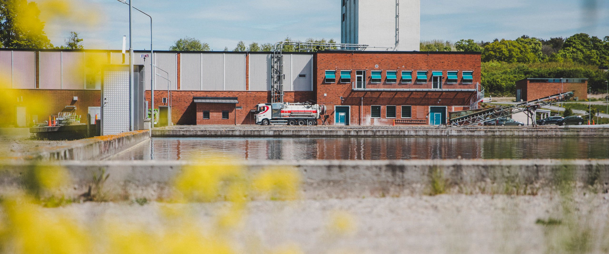 Ett reningsverk med en stor utomhusbassäng för vattenrening framför.