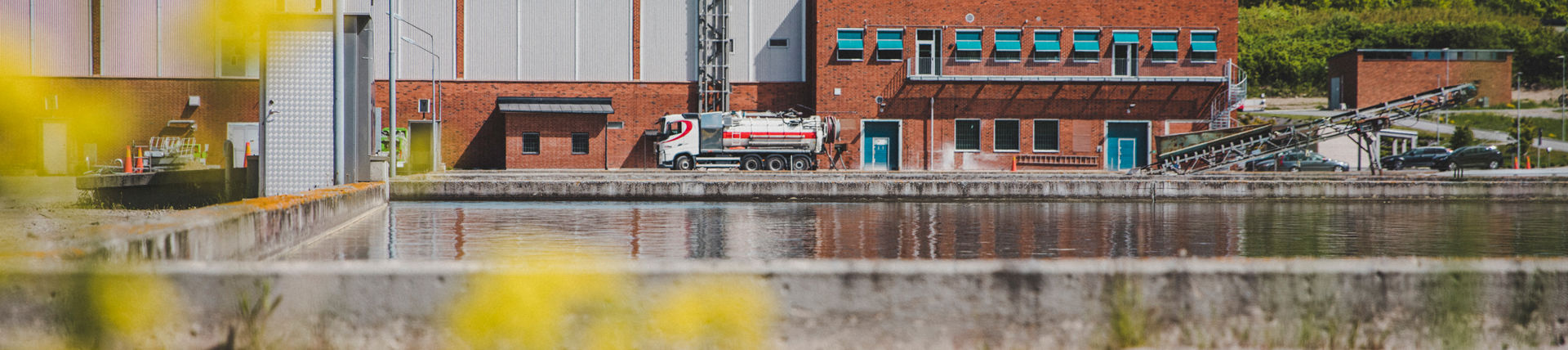 Ett reningsverk med en stor utomhusbassäng för vattenrening framför.