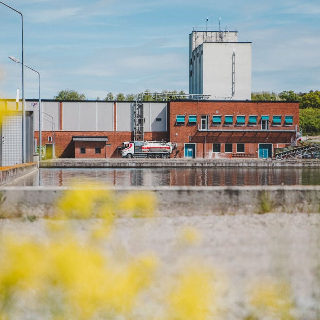 Ett reningsverk med en stor utomhusbassäng för vattenrening framför.