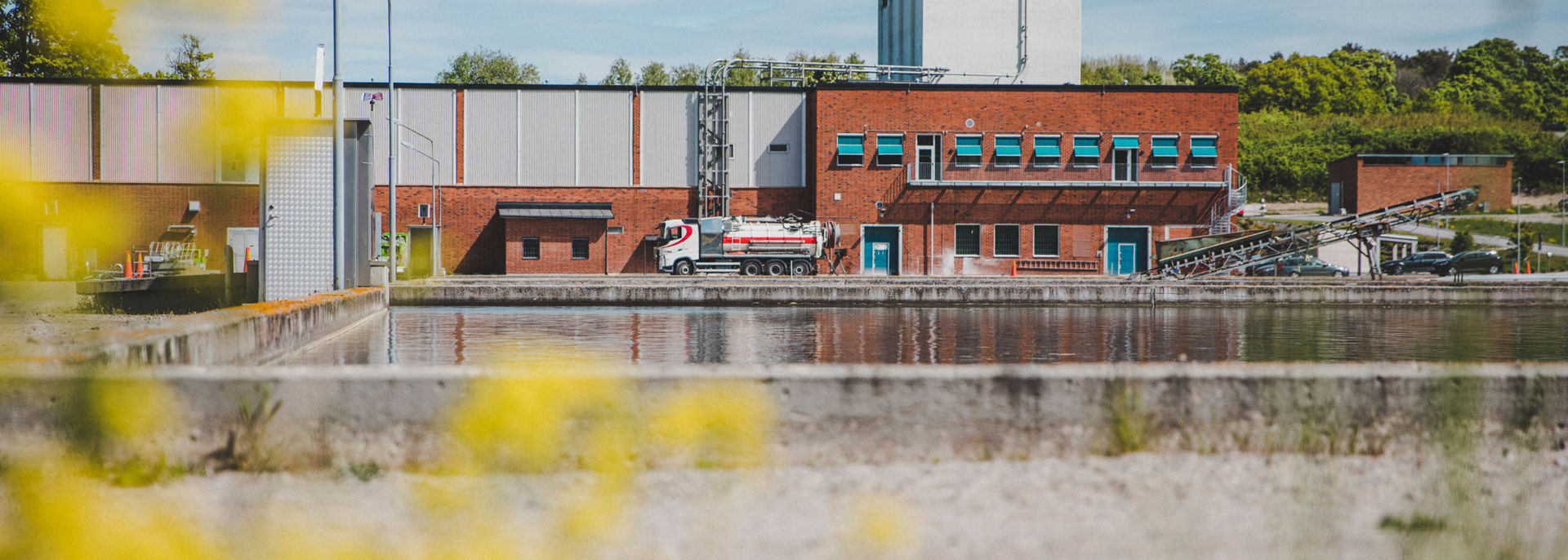 Ett reningsverk med en stor utomhusbassäng för vattenrening framför.